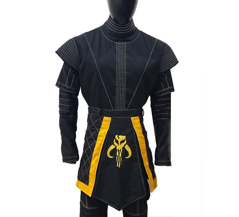 May include: Black costume with gold detailing, shown on a mannequin. The outfit includes a high collar, shoulder accents, and a belt. A gold emblem is on the front. The costume is suitable for cosplay or themed events.