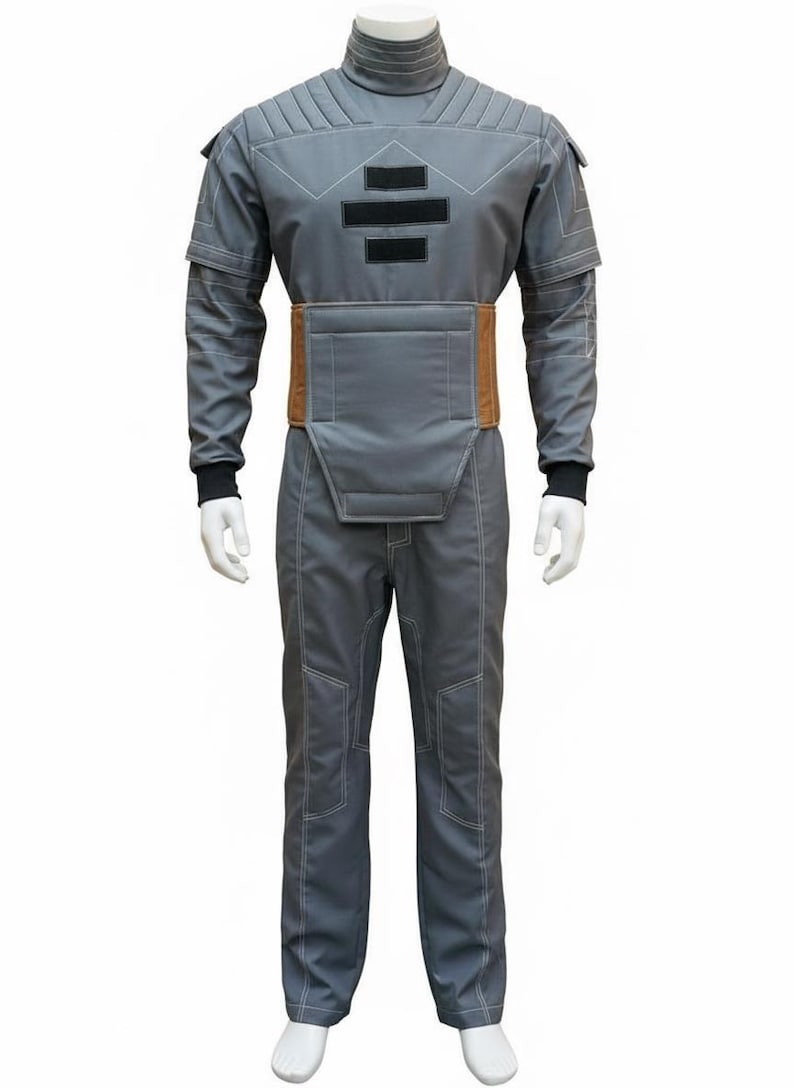 May include: A gray jumpsuit with a high collar, featuring a brown belt and black accents. The suit has white stitching details and is displayed on a mannequin. The overall design suggests a futuristic or sci-fi theme.