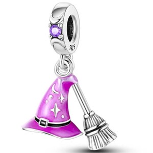 May include: A silver charm with a purple gemstone and a witch-themed pendant. The pendant features a pink witch hat with a black buckle and a silver broom. The hat is decorated with stars and a crescent moon.
