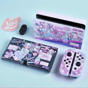 May include: A white and black Nintendo Switch console with a matching case and controller. The case and controller feature a pastel anime design with a girl, medical supplies, and the text "Tweeter" and "Live". A pink sticker with the word "Joy" is also present.