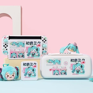 May include: A collection of white and light blue gaming accessories, including a console, a case, and a small storage box, all decorated with a cartoon character and Japanese text. A plush toy of the character is also visible. The accessories are designed for a gaming console.