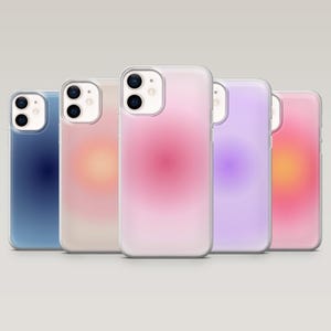 May include: Five smartphone cases with a gradient design in a row. The colours include blue, pink, peach, purple, and orange. The cases have a clear border and a glossy finish. The cases are for a smartphone.