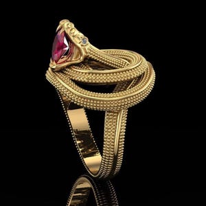Könnte beinhalten: Ein goldfarbener Schlangenring mit einem großen, ovalen, roten Edelstein als Schlangenkopf. Der Körper der Schlange windet sich um den Ring. Ein kleiner, klarer Edelstein ist in der Nähe des Kopfes gesetzt. Der Ring ist detailliert vor schwarzem Hintergrund.