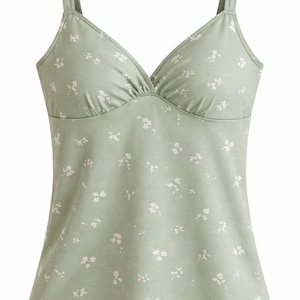 Op de afbeelding: Saliegroene camisole met een V-hals en dunne bandjes. De top is versierd met een delicaat wit bloemenpatroon. De stof lijkt zacht en licht, geschikt voor warm weer.