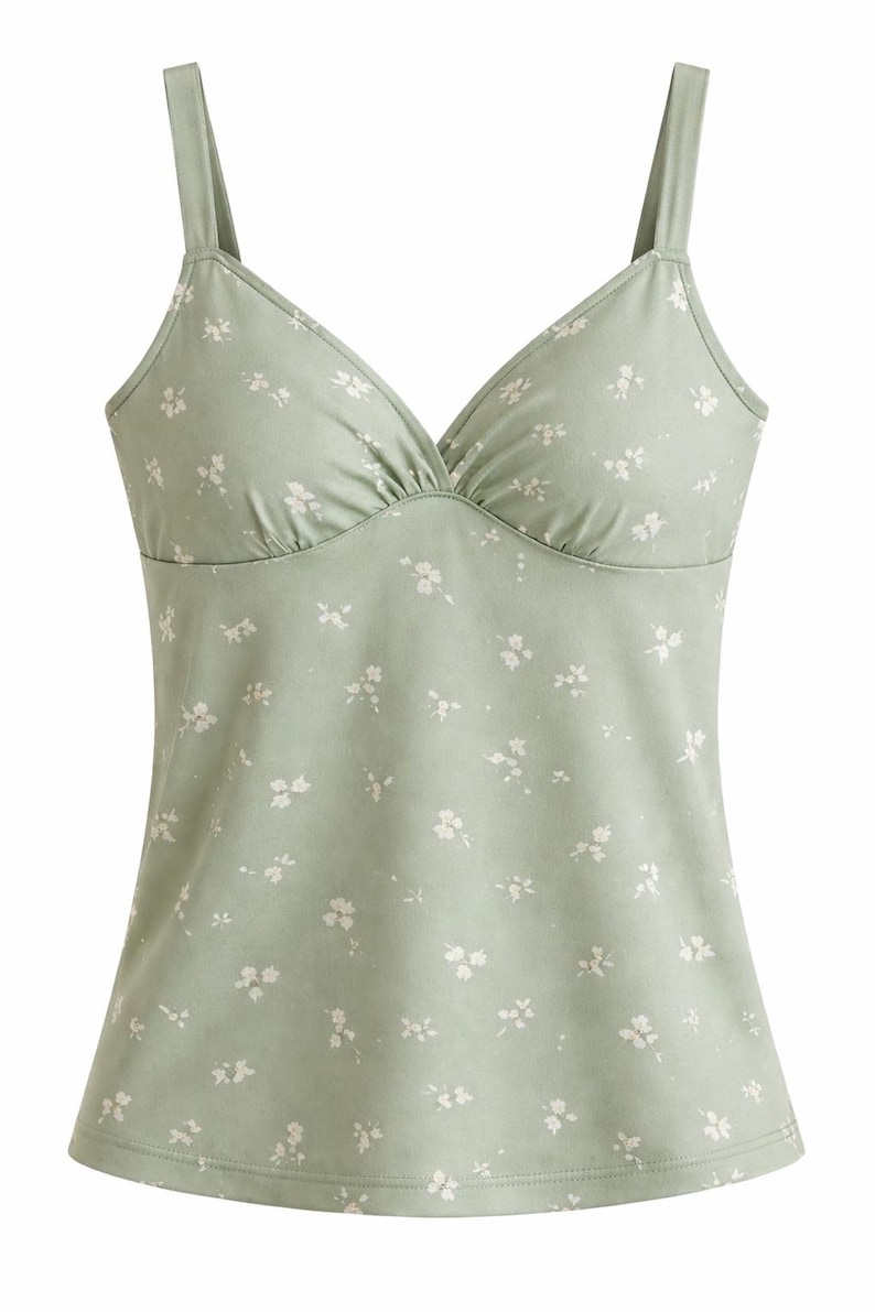 Op de afbeelding: Saliegroene camisole met een V-hals en dunne bandjes. De top is versierd met een delicaat wit bloemenpatroon. De stof lijkt zacht en licht, geschikt voor warm weer.