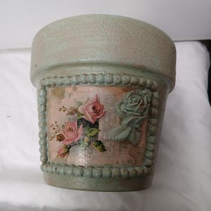 May include: A set of three ceramic mugs with a speckled, matte finish. The mugs are in shades of cream, light gray, and dark gray. Each mug has a simple, minimalist design and a rounded handle.