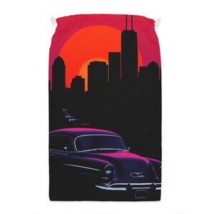 Puede incluir: Bolsa roja con cordón con un diseño retro. La imagen muestra un coche antiguo conduciendo hacia un horizonte urbano silueteado contra una vibrante puesta de sol. El coche es de color púrpura oscuro con un ribete blanco.