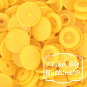 May include: A close-up image of a pile of bright yellow plastic snap buttons. The buttons are all the same size and shape, and they are arranged in a random pattern. The text "I Like Big Buttons!®" is visible in the lower right corner of the image.