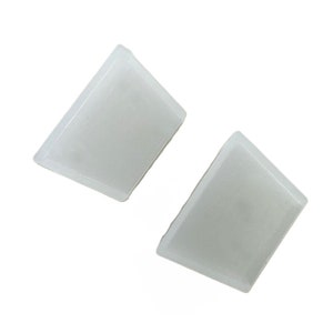 May include: Two opaque white triangular shaped earrings.