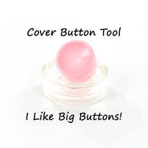 May include: A pink button cover tool, with the text "Cover Button Tool" above and "I Like Big Buttons!" below.