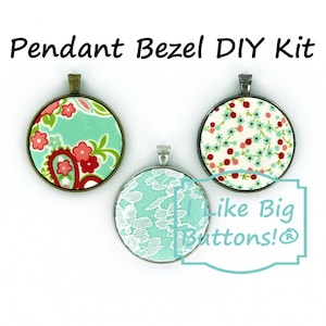 May include: Three pendant bezel DIY kits with different fabric designs. The kits feature a turquoise fabric with red and white floral patterns, a white fabric with red and turquoise floral patterns, and a white lace fabric on a turquoise background. The kits are labeled "Like Big Buttons!"