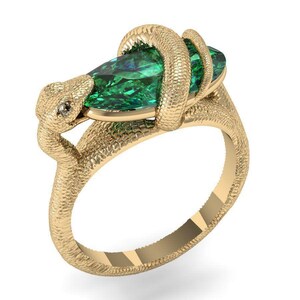 Könnte beinhalten: Ein goldener Ring mit einem strukturierten Schlangenmotiv, das sich um einen großen, marquise-geschliffenen grünen Edelstein windet. Der Schlangenkopf befindet sich an einem Ende des Steins und der Körper bildet den Ring mit einer detaillierten Schuppenstruktur.