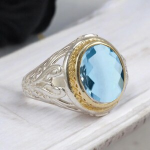 Anillo de hombre bicolor de aguamarina, filigrana ovalada vintage, engaste dorado y banda de plata, con trabajo de calado.