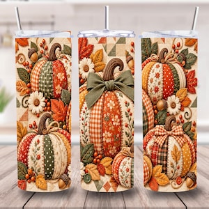 Puede incluir: Un vaso cilíndrico con tapa transparente y pajita, con un patrón repetitivo de calabazas estilo patchwork en tonos naranja, verde y crema, acentuado con hojas de otoño, bellotas, flores pequeñas y lazos de tela sobre un fondo acolchado.