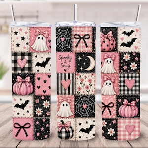 May include: A cylindrical tumbler with a straw featuring a patchwork design in pink, black, and white. The pattern includes ghosts with bows, pumpkins, bats, hearts, flowers, spiderwebs, and the text Spooky & Snug. The design has a clear lid.