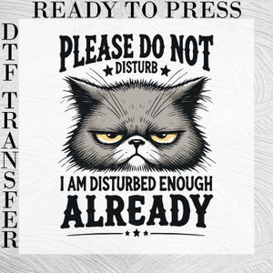 May include: A DTF transfer featuring a graphic of a grumpy grey cat with yellow eyes. The text reads: READY TO PRESS, PLEASE DO NOT DISTURB, I AM DISTURBED ENOUGH ALREADY. The design is black and white with a grey cat illustration on a white background.