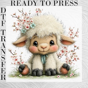 May include: A DTF transfer featuring a cute cartoon lamb with fluffy white fur, rosy cheeks, and large, expressive eyes. The lamb is adorned with floral accents and the text "READY TO PRESS".