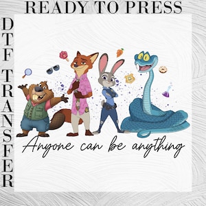 Pu&ograve; includere: Un foglio di trasferimento DTF con il testo READY TO PRESS e DTF TRANSFER. La grafica mostra un castoro, una volpe, un coniglio e un serpente blu con il testo Anyone can be anything. Le piccole icone includono una lente d'ingrandimento, occhiali da sole, una carota, un distintivo, una ciambella e una boccetta.