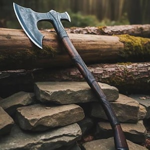 Puede incluir: Un hacha detallada con una cabeza de metal oscuro y un mango de madera. La cabeza del hacha presenta diseños intrincados y una hoja afilada. El mango es de color marrón oscuro con grabados decorativos. El hacha descansa sobre piedras y troncos, con un fondo de bosque.