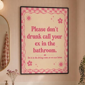 May include: A rectangular wall poster in a black frame featuring a cream background with a pink checkered border. The text reads: Please don't drunk call your ex in the bathroom. Do it in the living room so we can listen. Pink flowers and stars decorate the corners.