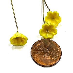 May include: Three yellow flower embellishments with gold wire stems. The flowers are about the size of a UK penny.