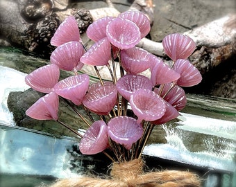 May include: A bouquet of small, delicate, pink glass flowers with a rustic brown twine base.