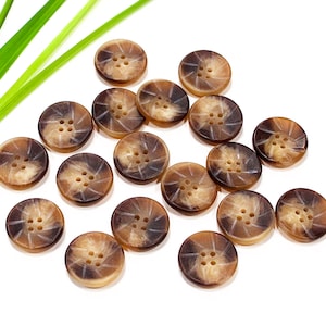 May include: A collection of 15 brown and tan horn buttons with a starburst design and four holes each.