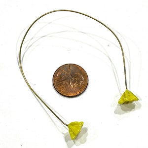 May include: A pair of yellow flower-shaped charms attached to a thin gold wire.