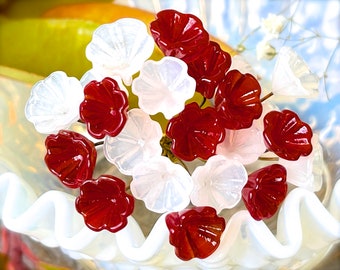 May include: A cluster of red and white glass flower-shaped beads. The beads are arranged in a bouquet-like shape and have a glossy finish.