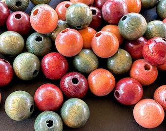 May include: A collection of wooden beads in various colors, including red, orange, and green. Each bead is spherical with a hole drilled through the center. The beads have a natural wood grain texture and a glossy finish, suitable for jewelry making.