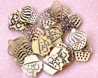 May include: A collection of light-coloured wooden buttons shaped like cupcakes. Each button features laser-cut details and dark brown engraved lines depicting frosting swirls, sprinkles, and decorative patterns on the cupcake liners.