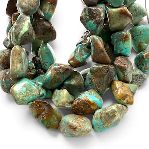 May include: A strand of irregular, tumbled turquoise gemstone beads featuring a vibrant mix of bright cyan and deep teal hues, interspersed with prominent dark brown and tan matrix veining throughout each polished, organic-shaped stone.