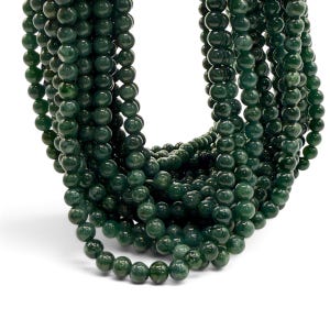 May include: A collection of multiple strands of dark forest green spherical beads. The beads have a smooth, polished, and reflective surface, arranged in a dense, cascading cluster that creates a deep, monochromatic color palette throughout.