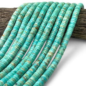 May include: Multiple strands of flat, disc-shaped turquoise beads arranged in parallel rows. Each bead features a vibrant cyan blue color with natural brown matrix veining, creating a consistent, textured appearance across the entire collection.