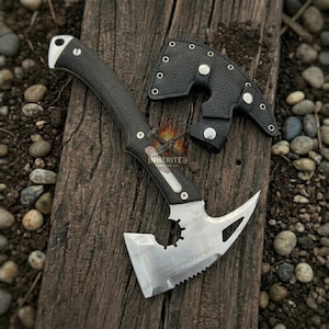 May include: A black and silver tactical tomahawk with a serrated edge and a black handle. The tomahawk is shown with a black leather sheath. The text "Inherited Forging Co" is visible on the blade.