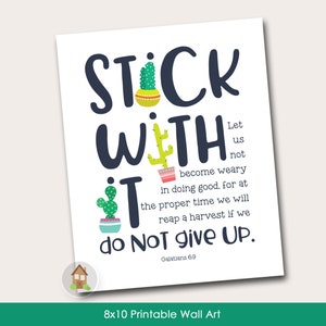 以下が含まれることがあります： 「Stick With It」の文字がネイビーブルーで描かれた、サボテンのイラストが特徴の20x25cmの印刷可能なウォールアートプリント。聖書の言葉と「do NOT give UP」の文字が含まれています。