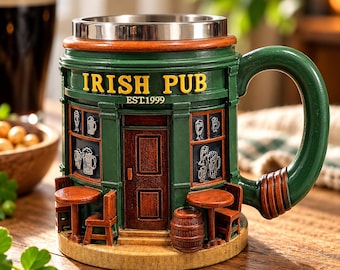 Puede incluir: Una taza verde y marrón con forma de fachada de pub irlandés con un borde de metal plateado. El exterior presenta el texto IRISH PUB EST.1999, una puerta central, mesas pequeñas, sillas, un barril e iconos de jarras en las ventanas.