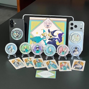 May include: A collection of Witch Hat Atelier merchandise including two smartphones with circular phone grips, six circular character badges on clear stands, six rectangular character cards, and one rectangular card, all featuring anime-style illustrations.