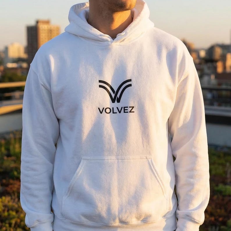 May include: White hoodie with a front pocket and a hood. The hoodie features a black logo with the word "VOLVEZ" printed below the logo. The hoodie is made of a soft material.