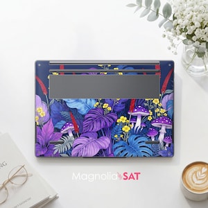 May include: A laptop skin featuring a vibrant botanical pattern with purple and blue monstera leaves, red stalks, yellow wildflowers, and purple mushrooms with white spots on a dark blue background. The design covers the underside of a laptop.