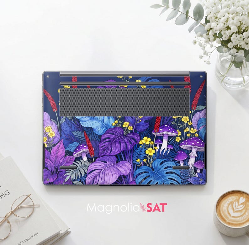 May include: A laptop skin featuring a vibrant botanical pattern with purple and blue monstera leaves, red stalks, yellow wildflowers, and purple mushrooms with white spots on a dark blue background. The design covers the underside of a laptop.
