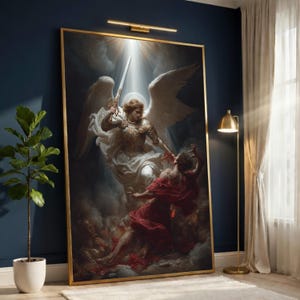 May include: A large rectangular framed wall art print depicting a winged figure in golden armour holding a sword aloft, standing over a figure in a red robe. The scene is set against a dark, cloudy background with dramatic lighting and a golden frame.