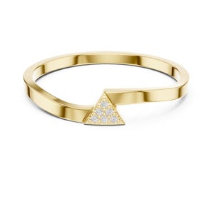 Op de afbeelding: Een gouden ring met een gladde, gepolijste band die buigt om een driehoekig middelpunt te vormen. De driehoek is bezet met zes kleine, heldere, rondgeslepen stenen die in een cluster zijn gerangschikt op het metaal.