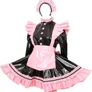 May include: A black and pink maid costume set. The outfit includes a black dress with pink accents, a matching apron, a ruffled collar, and a headband. The dress features a shiny, patent leather-like material.