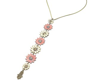 May include: A gold necklace with a delicate chain and a pendant featuring a hamsa hand charm and a row of pink and white enamel flower charms.