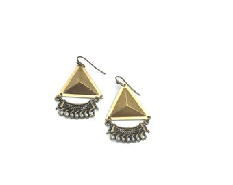 May include: A pair of gold triangle earrings with a dangling chain detail.