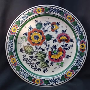 May include: A white ceramic mug with a black handle and the text "But First, Coffee" in a black, handwritten-style font. The mug is on a white surface.