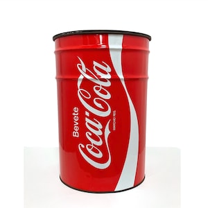 May include: A cylindrical red metal container featuring the white Coca-Cola logo script. The text Bevete is printed vertically on the left, and the text MARCHIO REG is printed vertically on the right. The container has a dark rim at the top and bottom.