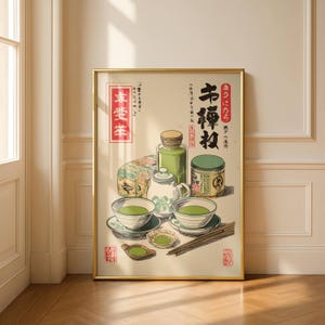Op de afbeelding: Een ingelijste prent met een stilleven van Japanse theeceremonie-artikelen. De afbeelding toont theekommen, een theepot, theebussen en eetstokjes. De prent heeft Japanse tekst en zit in een gouden lijst.