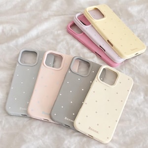 May include: A white ceramic mug with a black handle and the text "But First, Coffee" in a black, handwritten-style font. The mug is on a white surface.